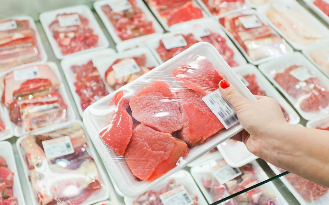 Packaged meat with woman hand in the supermarket