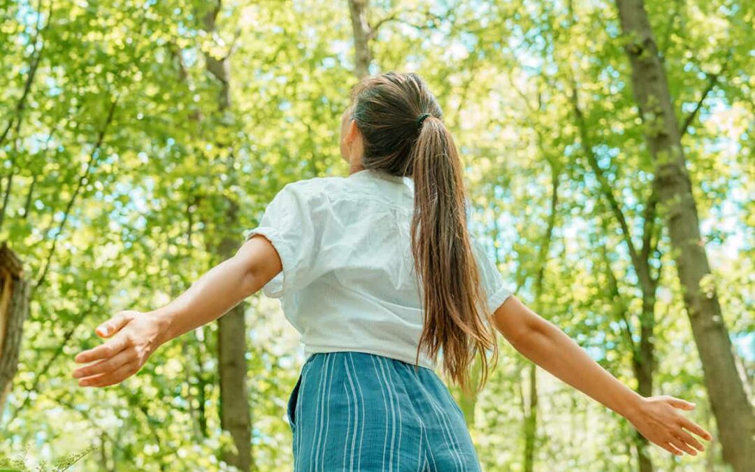 Frau atmet saubere Luft in der Natur Wald