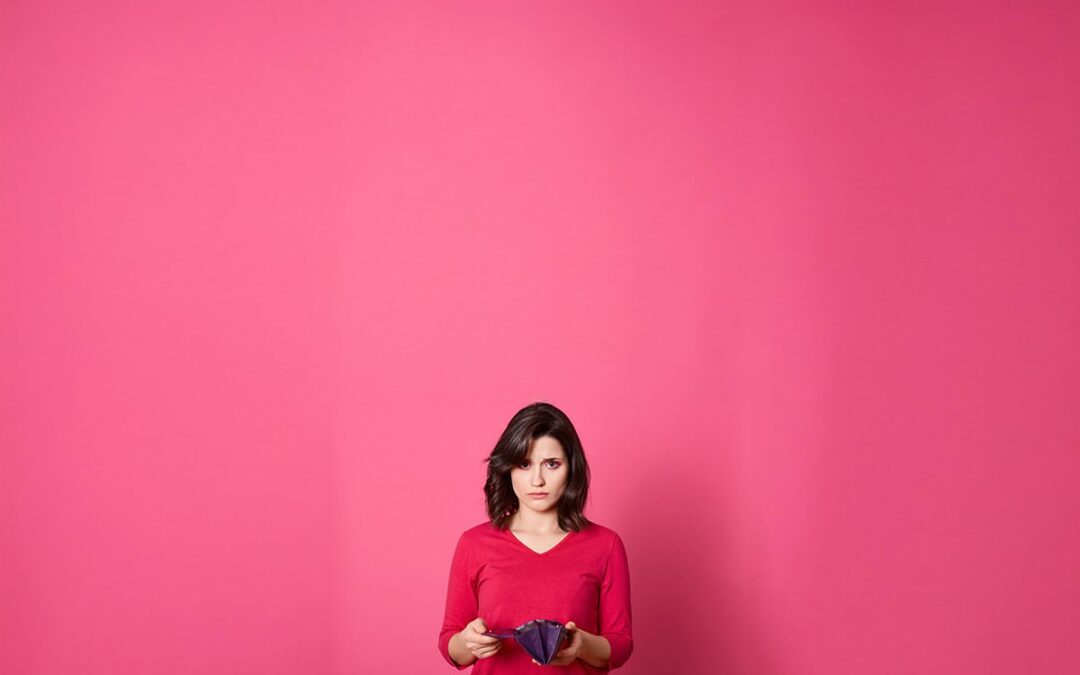 Frau mit leerem Geldbörserl auf rosa Hintergrund (c) AdobeStock_363272016