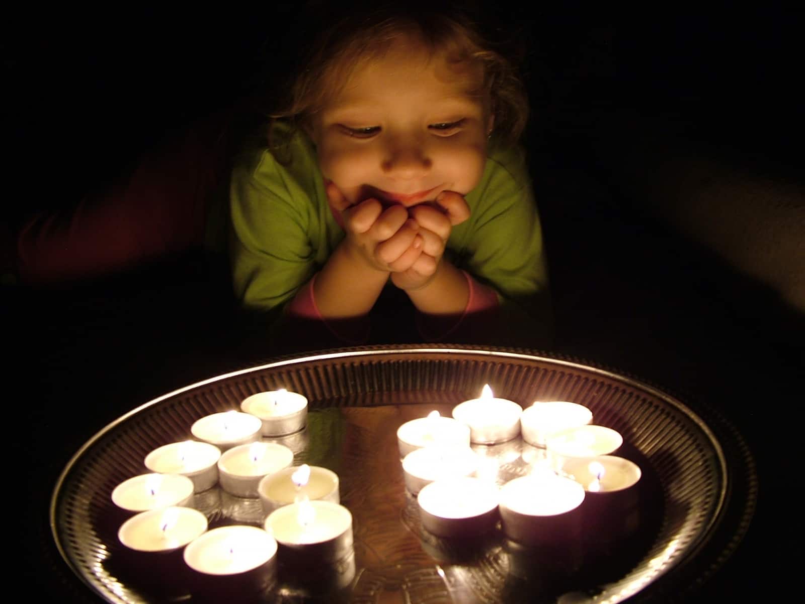 Ein Kind genießt die Earth Hour bei Kerzenlicht