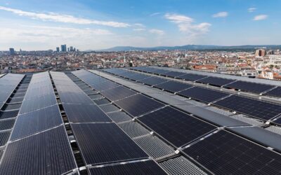 Auf dem Bild ist eine große Photovoltaik-Anlage auf dem Dach des Haus des Meeres in der Sonne zu sehen. Im Hintergrund ist eine Stadtkulisse zu sehen.